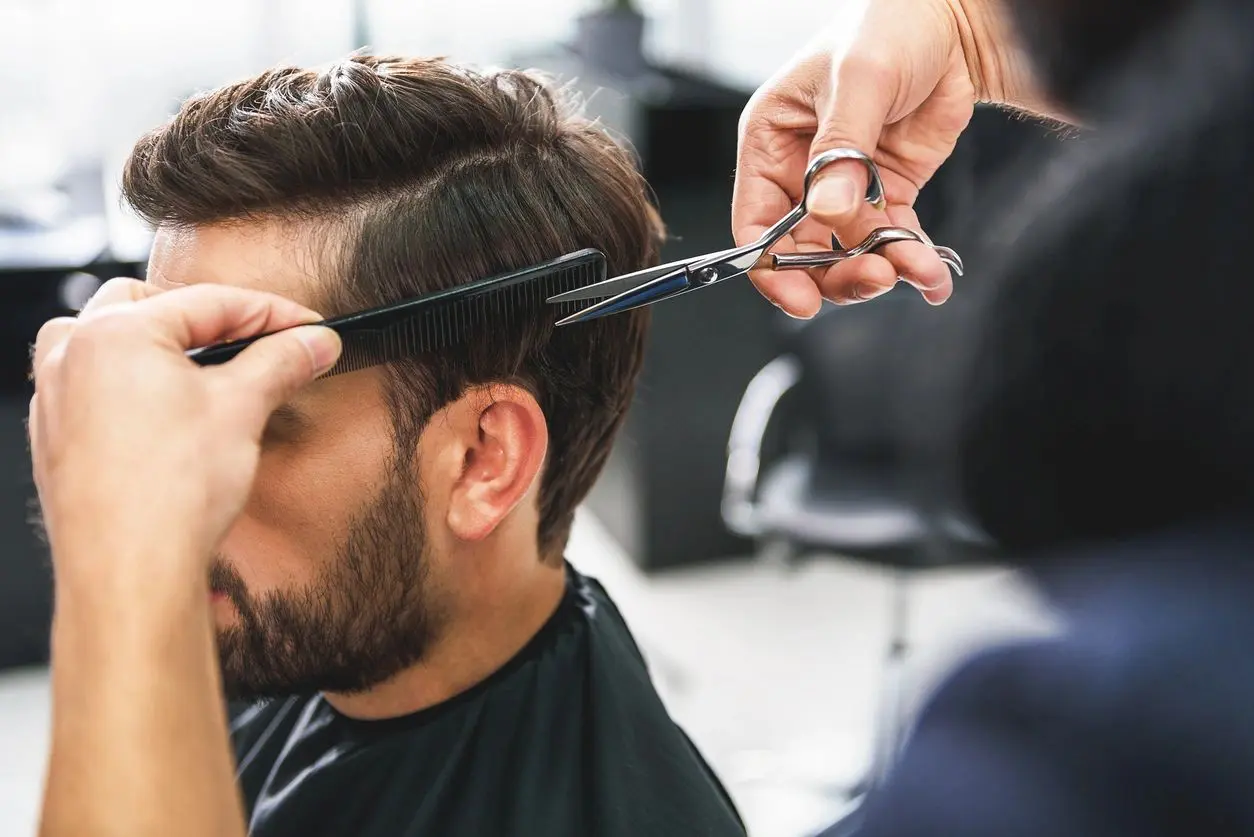 A man getting his hair cut by a barber