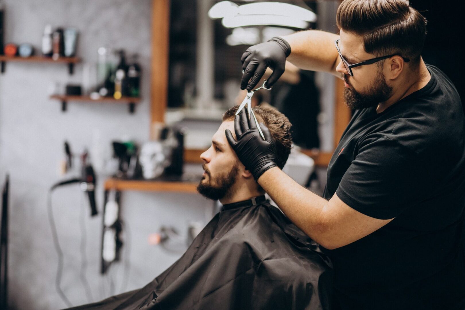 A man getting his hair cut by another person